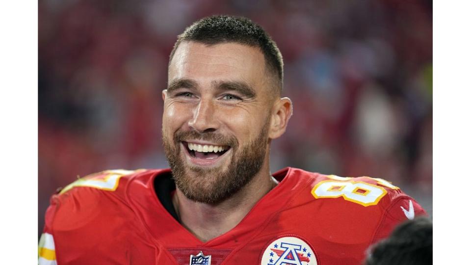 Travis Kelce smiling in his Kansas City Chiefs jersey
