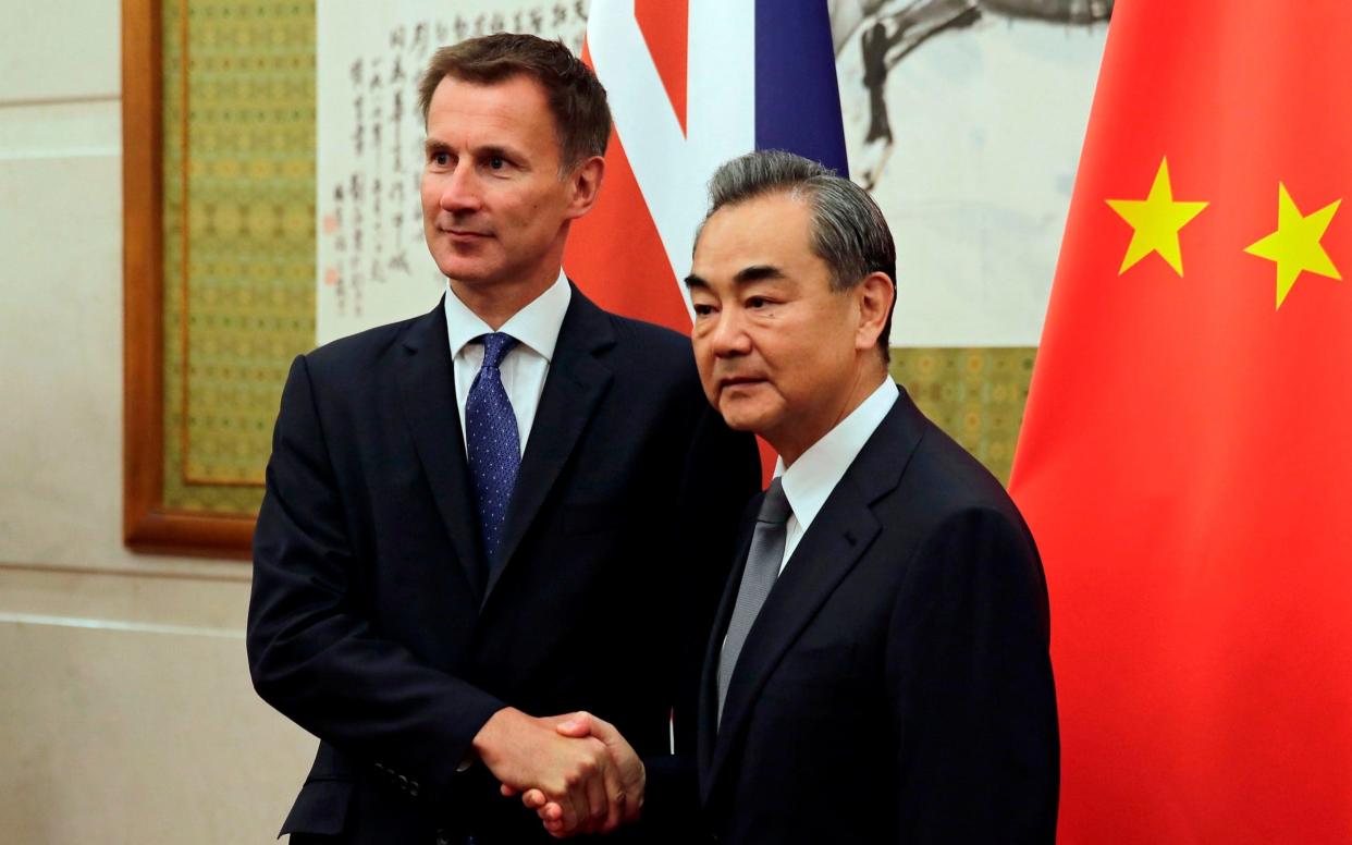 Foreign Secretary Jeremy Hunt shakes hands with his Chinese counterpart Wang Yi - AFP