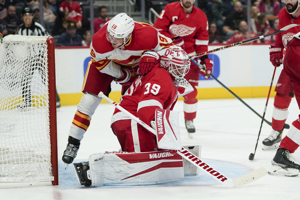 Calgary Flames left wing Matthew Tkachuk (19) hits Detroit Red Wings goaltender Alex Nedeljkovic (39) in the third period of an NHL hockey game Thursday, Oct. 21, 2021, in Detroit. (AP Photo/Paul Sancya)