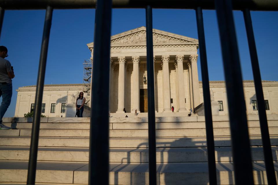A person has their photo taken outside the Supreme Court on Friday, April 21, 2023.