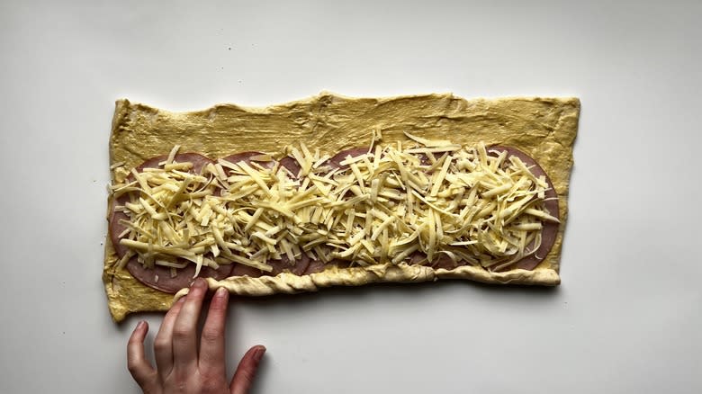 hands rolling up croissant dough