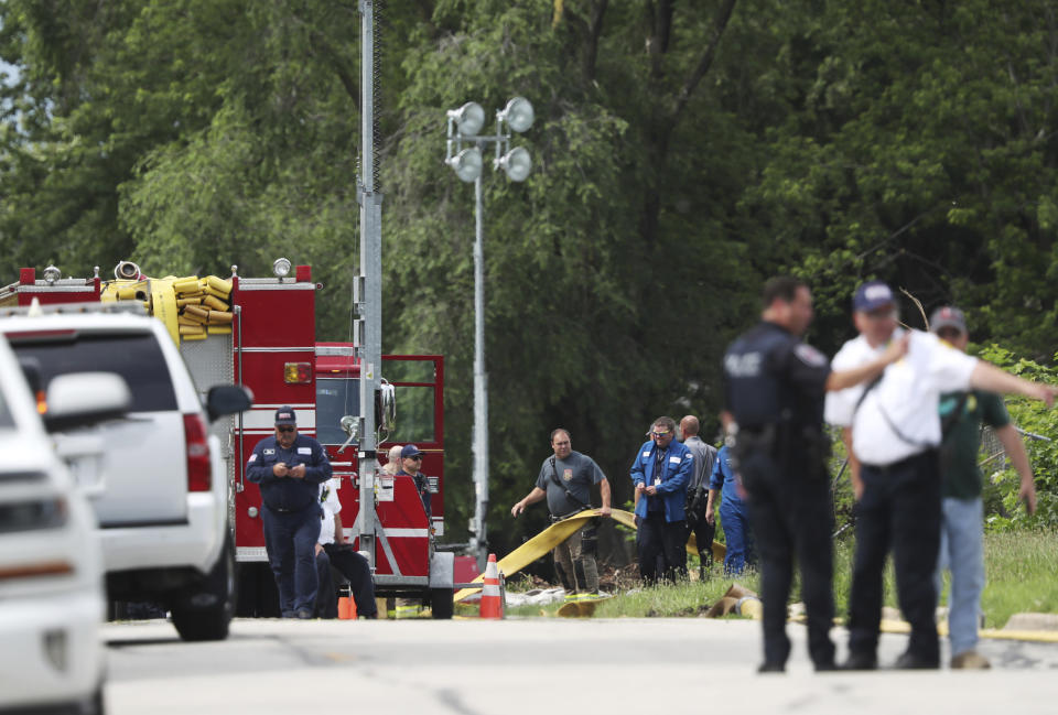 Fire and police officials stage near a burned building in the 900 block of East Benton Street Wednesday, June 30, 2021, in Morris, Ill. Lithium batteries exploded loudly overnight Tuesday inside a burning former paper mill in northern Illinois that officials had believed was long abandoned, and fire officials have decided to let the blaze burn out because they fear trying to extinguish it could trigger more explosions. (John J. Kim/Chicago Tribune via AP)