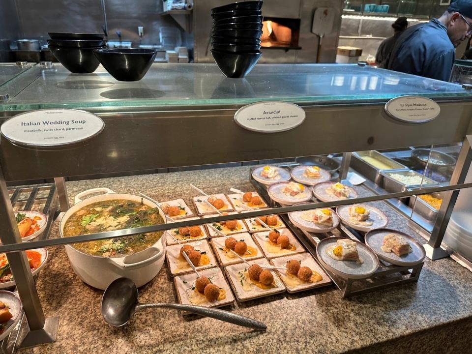 station at the Bacchanal buffet with Italian wedding soup, rice balls no a plate, and croque madame