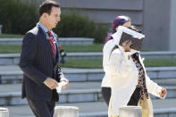 Iris Villalon, 44, of Ocean Springs, shields her face from media cameras as she crosses the street following an arraignment hearing at the Thad Cochran United States Courthouse in Jackson, Miss., on immigration crimes and other federal charges stemming from the largest single-state worksite enforcement action last year at a number of Mississippi poultry processing plants in which 680 illegal immigrants were detained, Thursday, Aug. 6, 2020, in Jackson, Miss. She was accompanied by her attorney John Reeves, left, and his assistant. (AP Photo/Rogelio V. Solis)