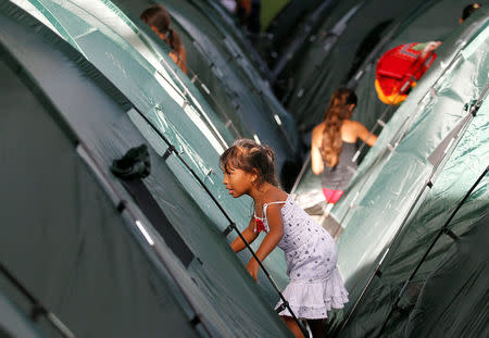 A girl is pictured at a tent camp at the municipal coliseum after the Colombian government ordered the evacuation of residents living along the Cauca river, as construction problems at a hydroelectric dam prompted fears of massive flooding, in Valdivia, Colombia May 18, 2018. REUTERS/Fredy Builes