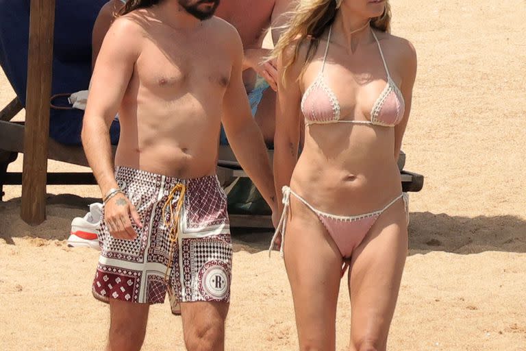 Mientras que la modelo lució su esbelta figura en un diminuto bikini en color rosa, su pareja optó por un traje de baño estampado. Los anteojos  y las gorritas deportivas, sus aliados playeros para combatir las altas temperaturas 