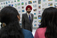 World Bank President Ajay Banga speaks with employees, by a wall display of children's art, Tuesday, April 16, 2024, at the World Bank in Washington. (AP Photo/Jacquelyn Martin)