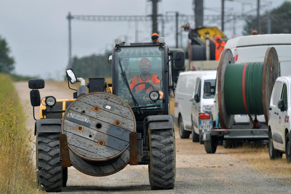 PHOTO: A worker transports a reel with cable to replace damaged cable lines in Vald' Yerres, near Chartres, on July 26, 2024,. (Jean-Francois Monier/AFP via Getty Images)