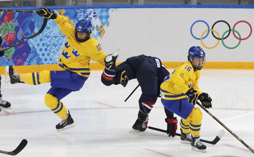 Sweden's Emilia Andersson (L) and Team USA's Hilary Knight collide with Sweden's Pernilla Winberg (R) during the first period of their women's ice hockey semi-final game at the Sochi 2014 Winter Olympic Games February 17, 2014. REUTERS/Grigory Dukor (RUSSIA - Tags: SPORT ICE HOCKEY OLYMPICS)