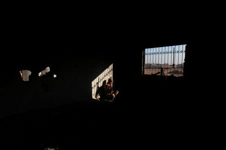 An Iraqi policeman sites at a house damage from the clashes in Qaraqosh, near Mosul, Iraq, December 9, 2016. REUTERS/Alaa Al-Marjani