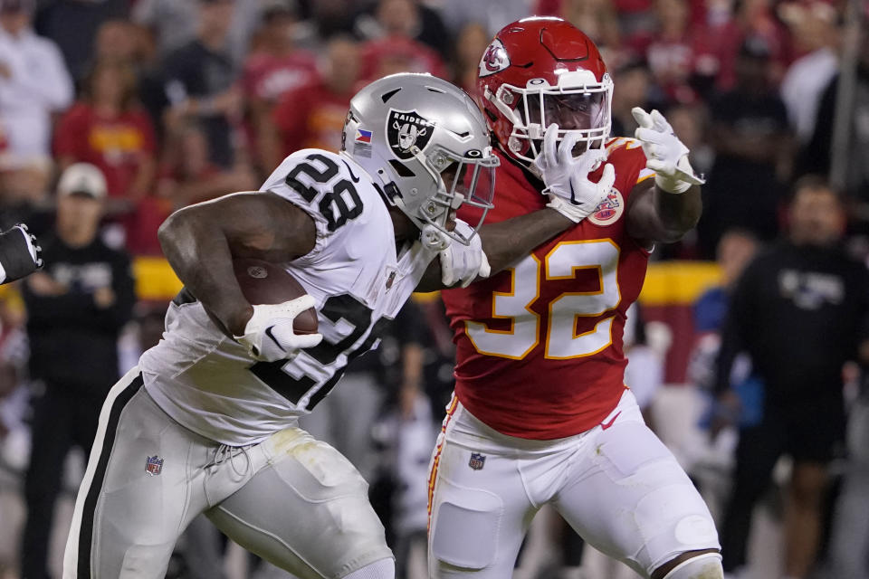 Las Vegas Raiders running back Josh Jacobs (28) runs with the ball as Kansas City Chiefs linebacker Nick Bolton (32) defends during the first half of an NFL football game Monday, Oct. 10, 2022, in Kansas City, Mo. (AP Photo/Ed Zurga)