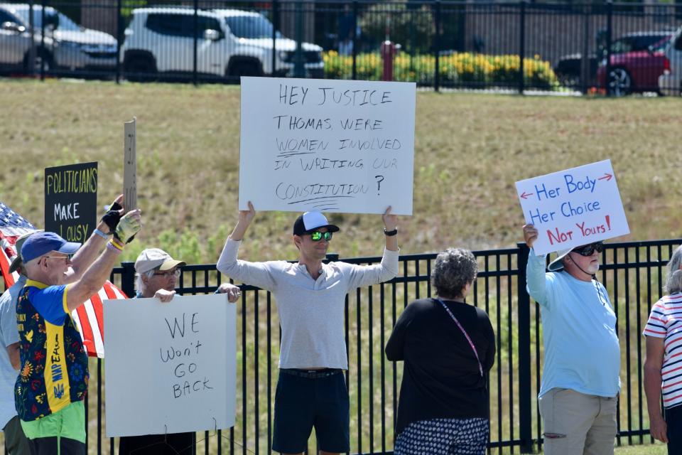 Pro-abortion rights protesters hold up signs along US-31 in front of the hole in downtown Petoskey on Sunday, July 3.