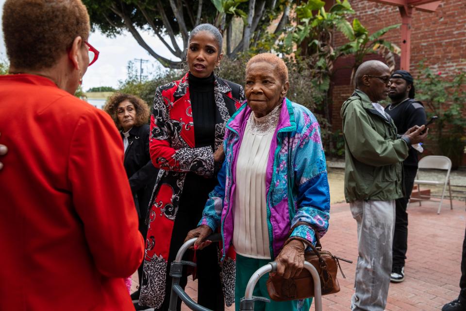 Areva Martin, left, attorney for the Section 14 Survivors group, stands with one of its members, 94-year-old Mary Lucas Spencer, following a press conference in Los Angeles on Tuesday.