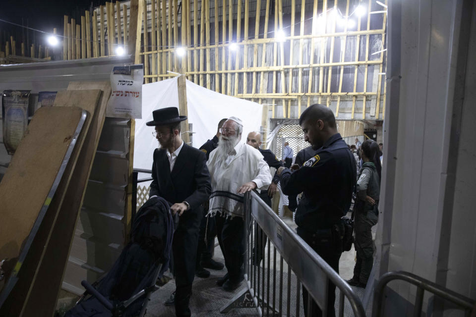 Ultra-Orthodox Jewish men leave a synagogue in Givat Zeev, outside Jerusalem, Sunday, May 16, 2021. Israeli medics say more than 150 people were injured in a fatal collapse of a bleacher at an uncompleted West Bank synagogue. (AP Photo/Sebastian Scheiner)