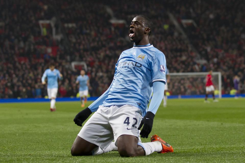 Manchester City's Yaya Toure celebrates after scoring against Manchester United during their English Premier League soccer match at Old Trafford Stadium, Manchester, England, Tuesday, March 25, 2014. (AP Photo/Jon Super)