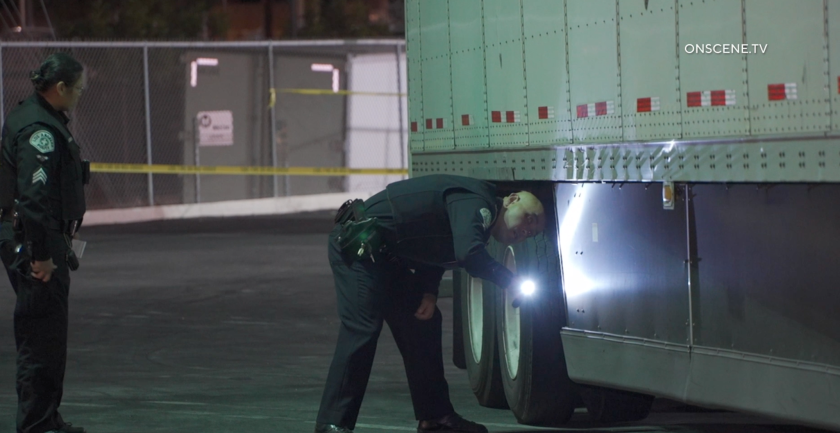 LAPD officers inspect a big-rig that ran over a woman sleeping at a Vons parking lot in Echo Park.