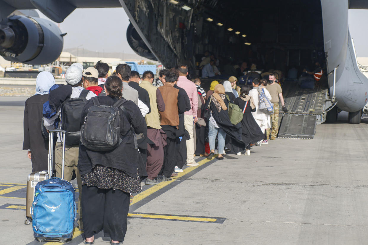 Evacuees board an evacuation flight in Kabul. (Lance Cpl. Nicholas Guevara/USMC/UPI/Shutterstock)