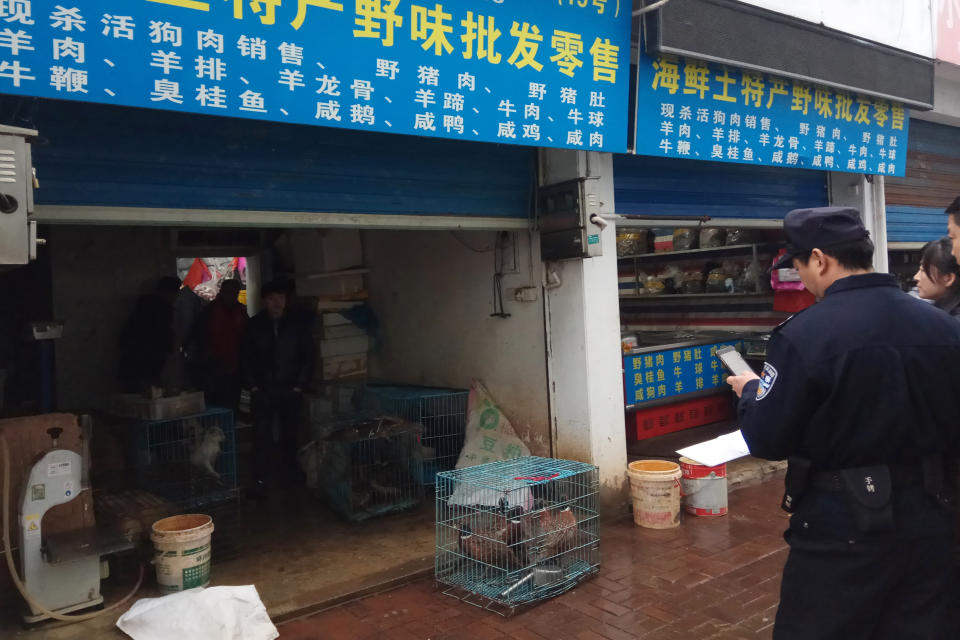 FILE - In this Jan. 9, 2020, file photo provided by the Anti-Poaching Special Squad, police gather outside a store suspected of trafficking in wildlife in the city of Guangde in central China’s Anhui province. As China enforces a temporary ban on the wildlife trade to contain the outbreak of a new virus, many are calling for a more permanent solution before disaster strikes again. (Anti-Poaching Special Squad via AP, File)