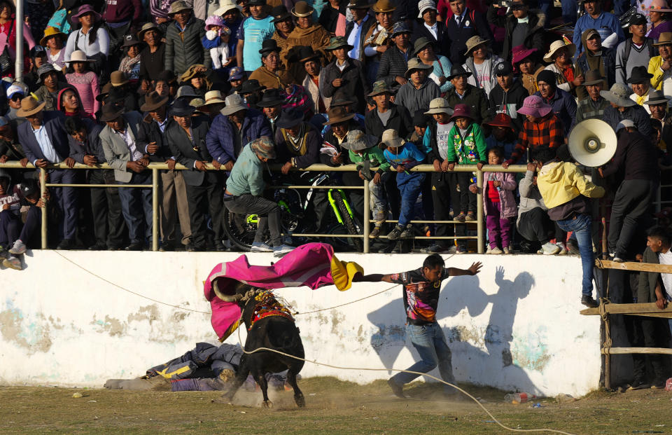 Un torero aficionado ondea el capote durante la festividad católica en honor de la Virgen del Rosario, en el pueblo andino de Huarina, Bolivia, el lunes 9 de octubre de 2023. Un grupo de novilleros aficionados alistas una actuación caricaturizada del toreo español, pero sin sacrificar a los toros. (AP Foto/Juan Karita)