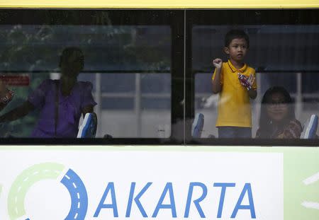 A boy looks out the window of a bus as it passes the location of yesterday's gun and bomb attack in central Jakarta January 15, 2016. REUTERS/Darren Whiteside