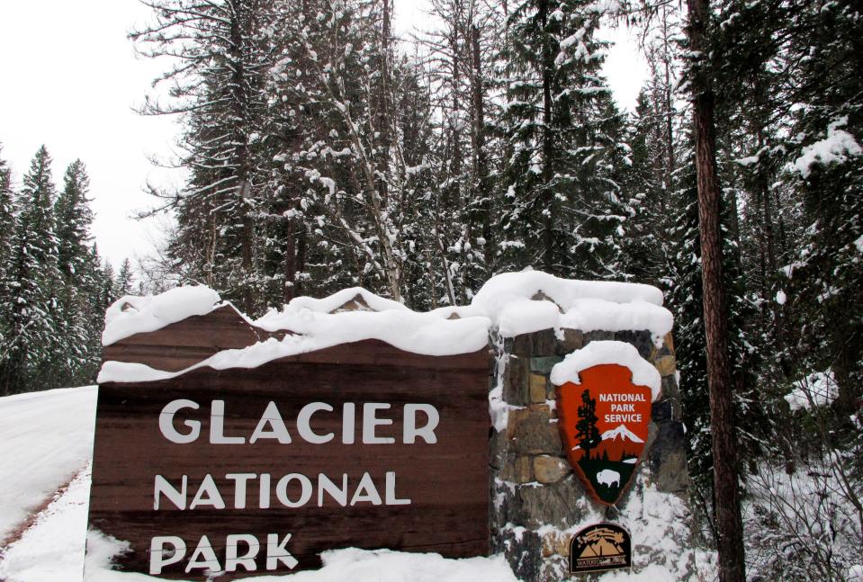 Snow covers the entrance sign to Glacier National Park in West Glacier, Montana, in this file photo from Dec. 11, 2012.
