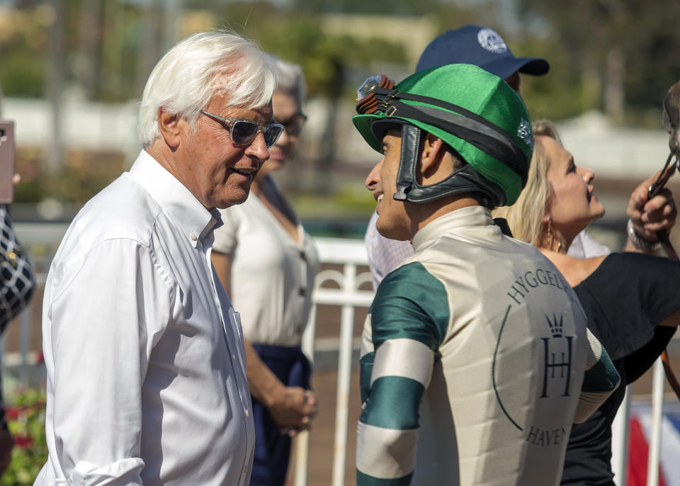 In this image provided by Benoit Photo, trainer Bob Baffert, left, celebrates with jockey John Velazquez, right, after Gamine's victory in the Grade II, $200,000 Great Lady M Stakes horse race Monday, July 5, 2021, at Los Alamitos Race Course in Cypress, Calif. (Benoit Photo via AP)