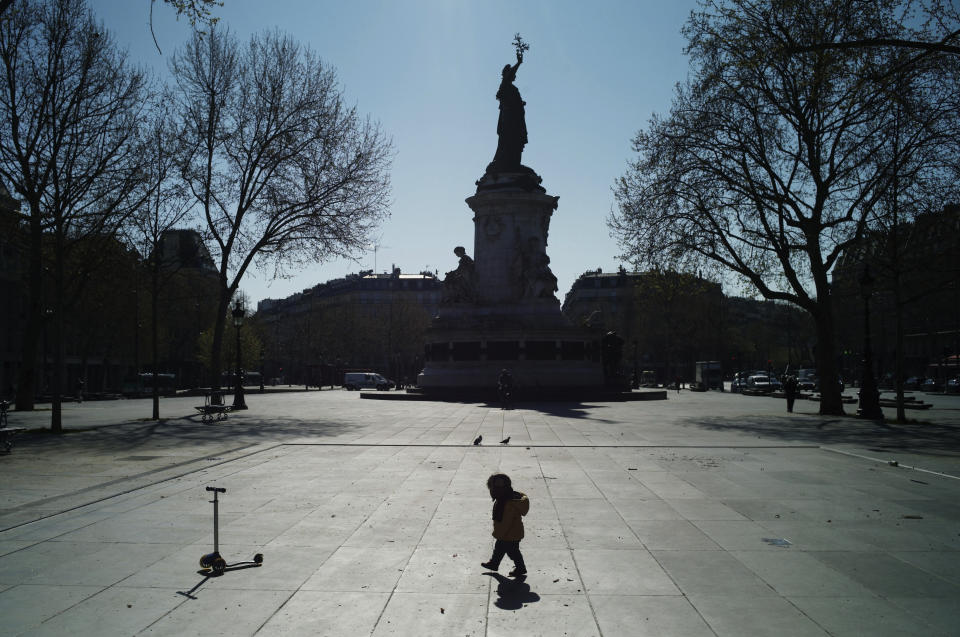 A child walks on the deserted Republique square during a nationwide confinement to counter the new coronavirus, in Paris, Wednesday, April 1, 2020. The new coronavirus causes mild or moderate symptoms for most people, but for some, especially older adults and people with existing health problems, it can cause more severe illness or death. (AP Photo/Thibault Camus)