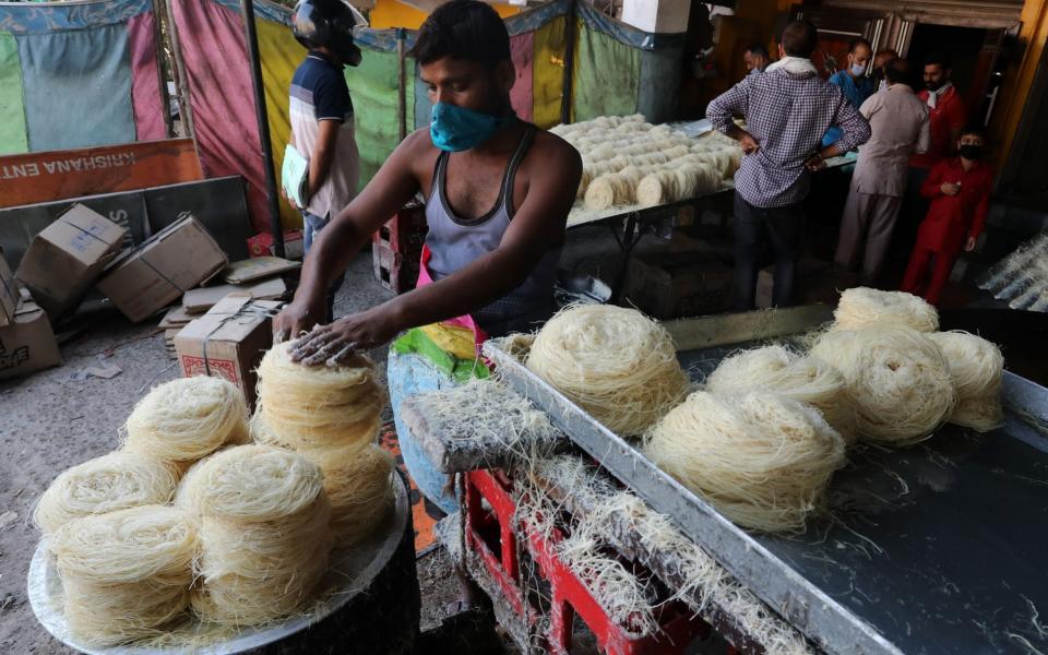 An Indian worker arranges vermicelli for the upcoming Hindu festival Karva Chauth in Tarore villag - Shutterstock 