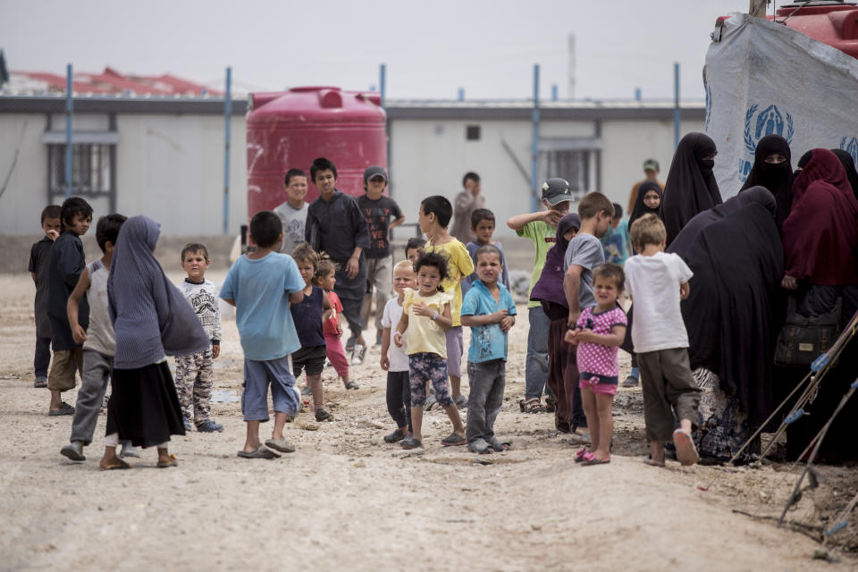 Women and children gather in front their tents at al-Hol camp that houses some 60,000 refugees, including families and supporters of the Islamic State group, many of them foreign nationals, in Hasakeh province, Syria, Saturday, May 1, 2021. Kurdish officials say security has improved at the sprawling camp in northeast Syria, but concerns are growing of a coronavirus outbreak in the facility. (AP Photo/Baderkhan Ahmad)