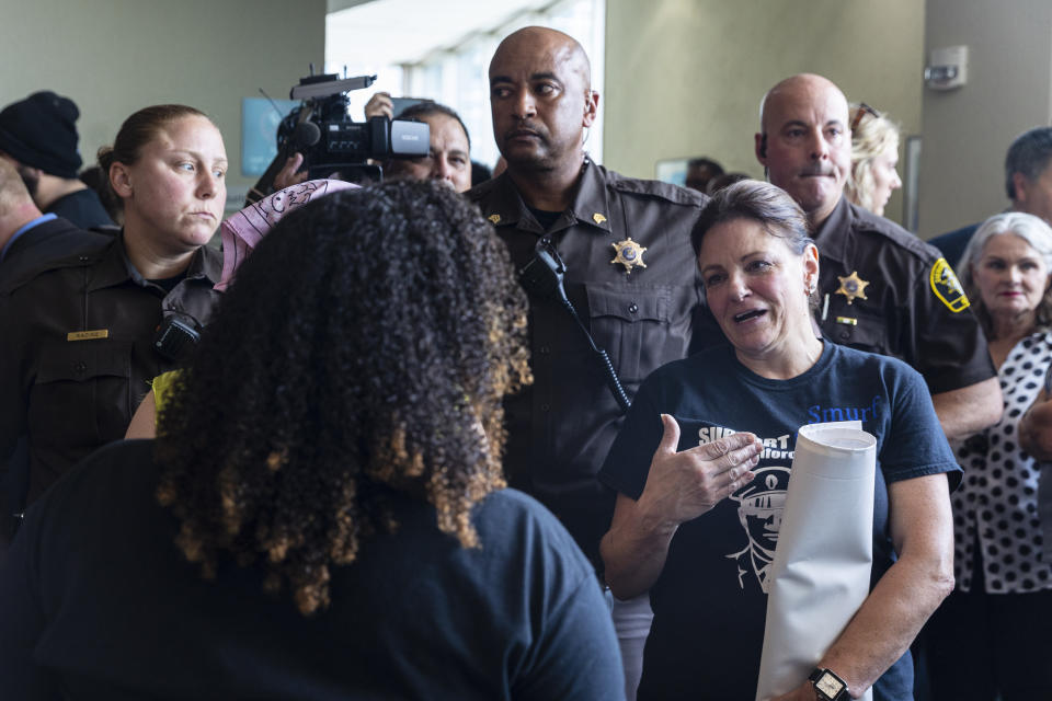 Supporters of Patrick Schurr and supporters of Christopher Schurr confront one another in the hallway outside of Kent County District Court where Grand Rapids Police officer Schurr appeared on video from jail, Friday, June 10, 2022 in Grand Rapids, Mich. A judge facing a packed courtroom set bond Friday at $100,000 for Schurr, a Michigan police officer charged with second-degree murder in the death of Patrick Lyoya, a Black man who was shot in the back of the head in April. (Joel Bissell/The Grand Rapids Press via AP)