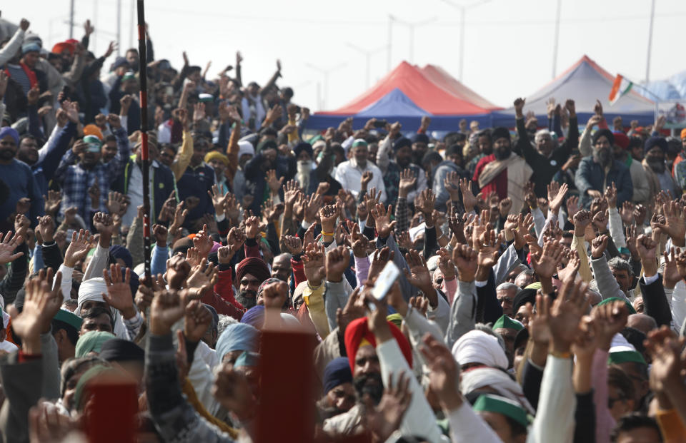 Farmers raise their hand as they shout slogans during a day-long hunger strike to protest against new farm laws, at the Delhi-Uttar Pradesh border, on the outskirts of New Delhi, India, Saturday, Jan. 30, 2021. Indian farmers and their leaders spearheading more than two months of protests against new agriculture laws began a daylong hunger strike Saturday, directing their fury toward Prime Minister Narendra Modi and his government. Farmer leaders said the hunger strike, which coincides with the death anniversary of Indian independence leader Mahatma Gandhi, would reaffirm the peaceful nature of the protests. (AP Photo/Manish Swarup)