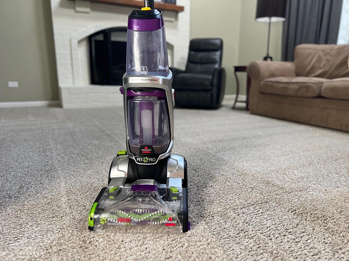 Bissell ProHeat 2X Revolution Pet Pro standing upright on freshly cleaned beige family room carpet.