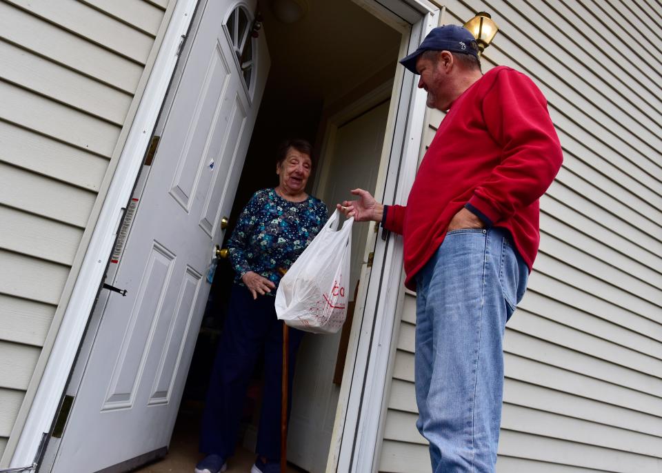 Lois Coats smiles as she opens her home's front door to receive a pre-made meal delivered by Dan Shelton on Wednesday, Nov. 16, 2022.