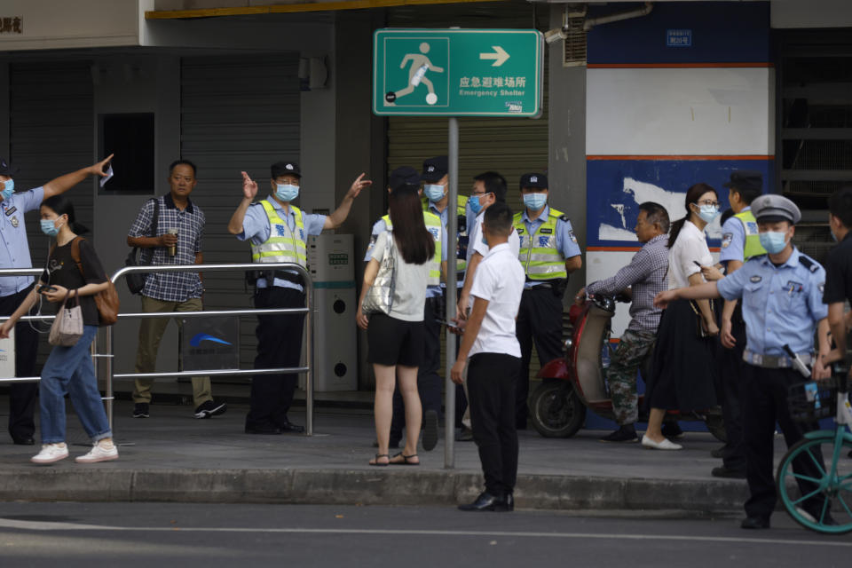 Unos policías chinos alejan a los residentes de un vecindario acordonado antes del cierre oficial del consulado de Estados Unidos en Chengdu, en el suroeste de China, el lunes 27 de julio de 2020. (AP Foto/Ng Han Guan)