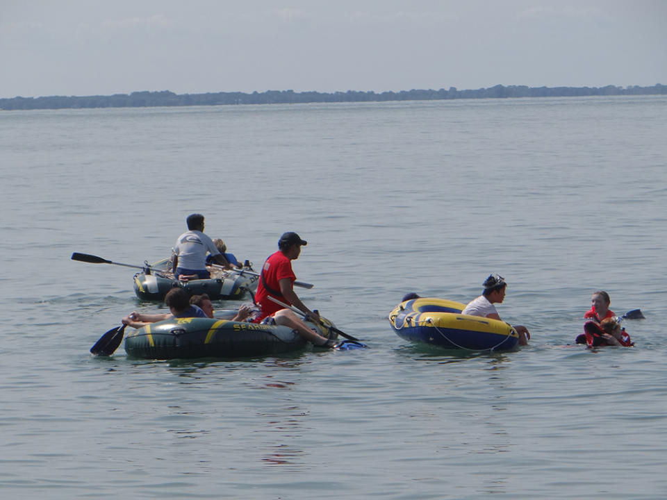 Students maneuver rafts to the GPS coordinates of the sunken scow W.R. Hanna while others look underwater to find it. (Patrick O’Donnell)
