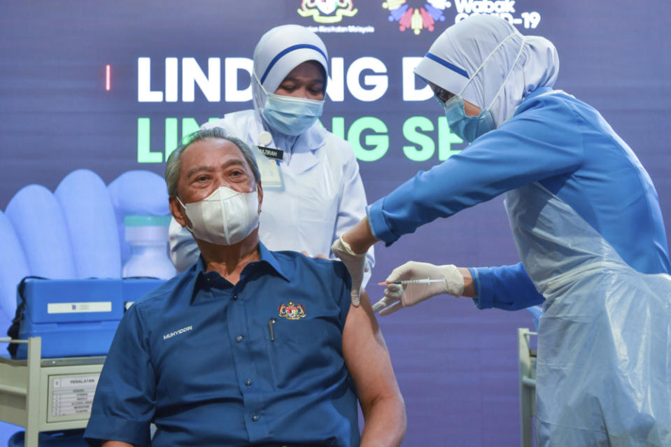 Then prime minister Tan Sri Muhyiddin Yassin receives the Pfizer BioNTech Covid-19 vaccine from Chief Nurse Lina Ibrahim at the Putrajaya District Health Office Precinct 11 February 24, 2021. — Bernama pic