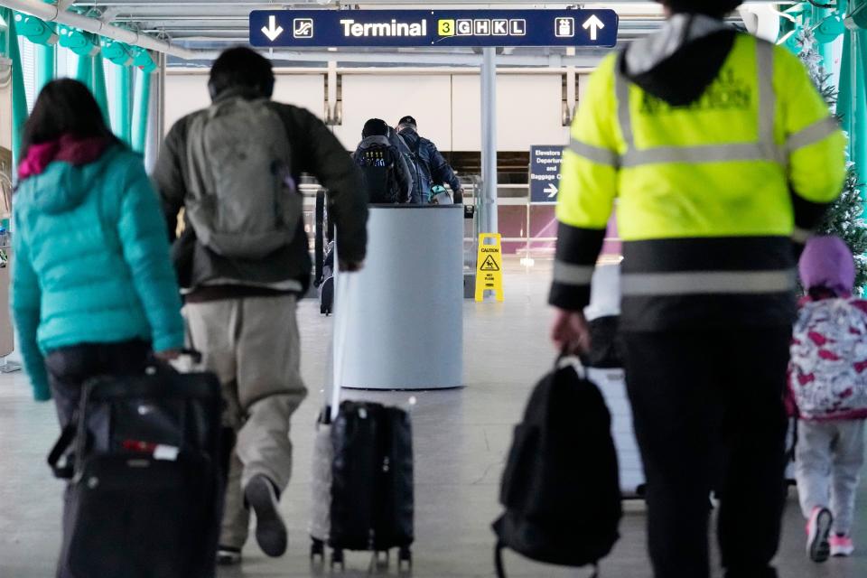 Travelers walk through Terminal 3 at the O'Hare International Airport in Chicago, Sunday, Jan. 14, 2024.