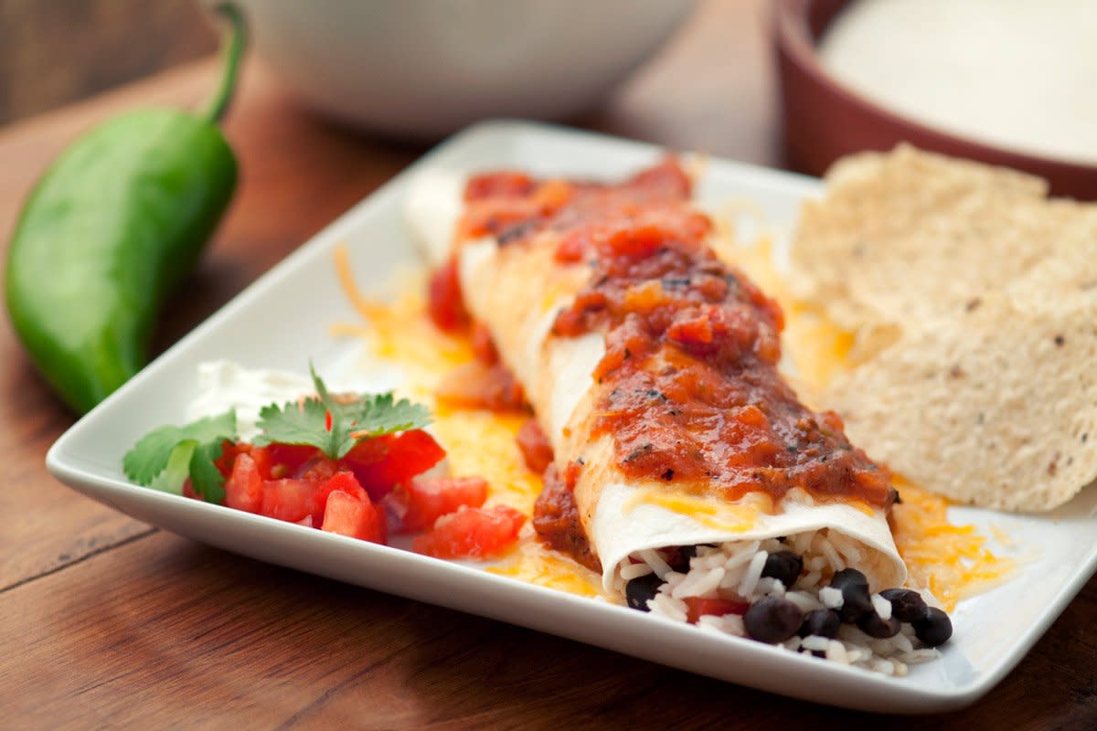 Black bean enchiladas sit on a plate. 