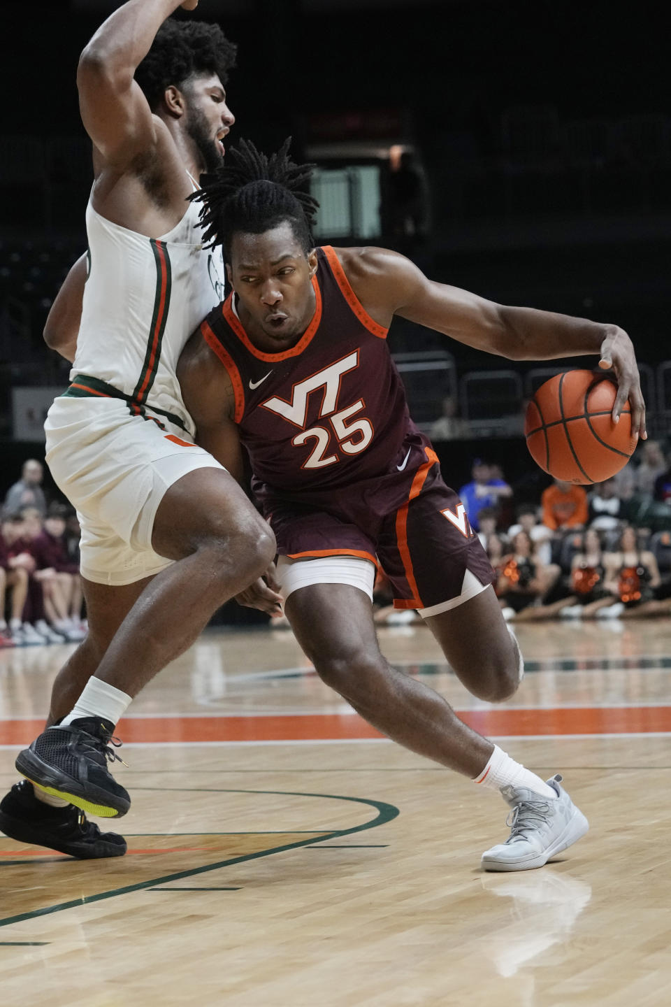 Virginia Tech forward Justyn Mutts (25) dribbles around Miami forward Norchad Omier (15) during the first half of an NCAA college basketball game, Tuesday, Jan. 31, 2023, in Coral Gables, Fla. (AP Photo/Marta Lavandier)