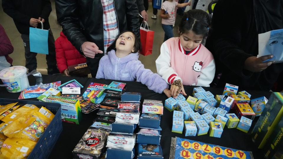Zeenat Faizi, 3, looks up at her father as she and sister Zainab, 6, pick out toys Friday at the Our Helpers toy drive at the Linden Comunity Center. Our Helpers is a Muslim women-run organization that been organizing a toy drive during the holy month of Ramadan.