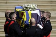 <p>Prince Philip's casket, covered in his personal standard and flowers, is carried into the chapel. </p>