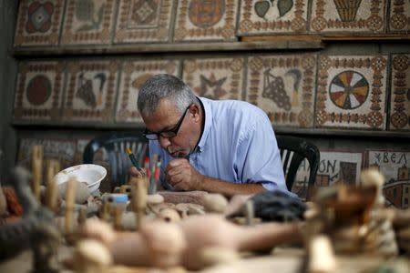 Archeology Nafez Abed cleans sculptures at his workroom, at Shati refugee camp in Gaza City, November 8, 2015. REUTERS/Suhaib Salem