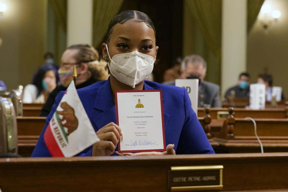 Tayte Williams a member of California's Electoral College holds up her ballot for Vice President-Elect, Sen. Kamala Harris at the state Capitol in Sacramento, Calif., Monday, Dec. 14, 2020. Williams was selected by Harris' to represent her at the Electoral College. (AP Photo/Rich Pedroncelli, Pool)