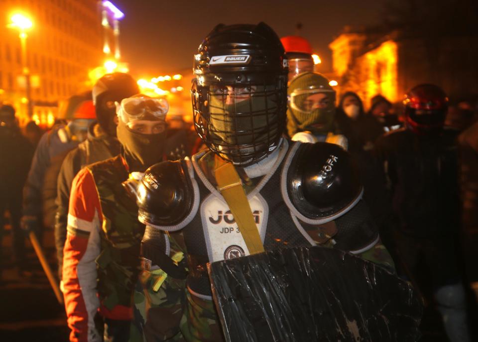 FILE - In this file photo taken on Monday, Jan. 20, 2014, Protesters clad in improvised protective gear prepare for a clash with police in central Kiev, Ukraine. Protesters in Kiev used improvised protective gear to protect themselves from stun grenades, rubber bullets and tear gas during clashes with police in central Kiev this week? After a night of vicious streets battles, anti-government protesters and police clashed anew Monday in the Ukrainian capital Kiev. Hundreds of protesters, many wearing balaclavas, hurled rocks and police responded with tear gas. (AP Photo/Sergei Grits, file)