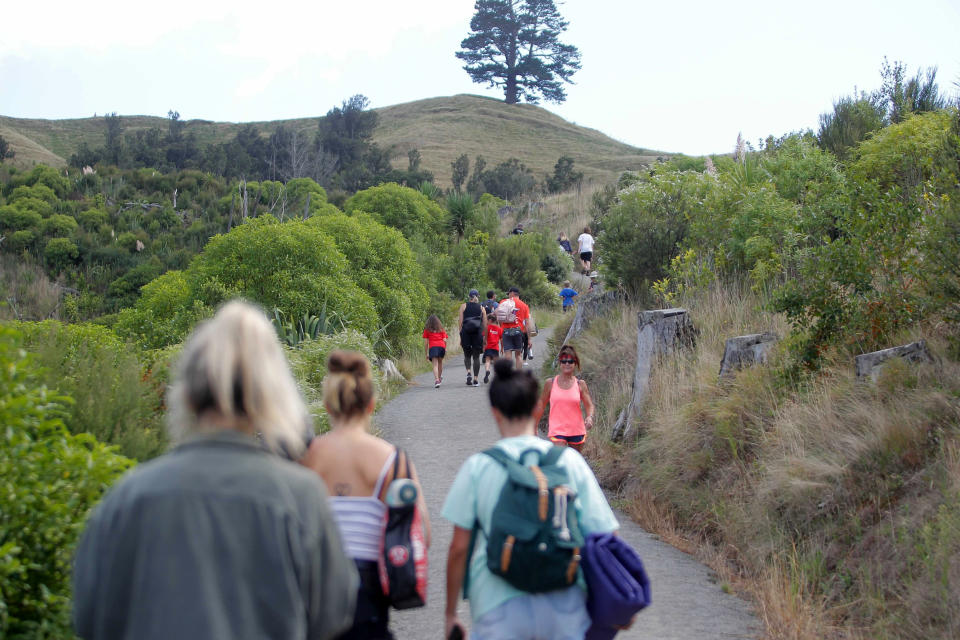 People walk up a hill above Papamoa Beach, New Zealand, as a tsunami warning is issued Friday, March 5, 2021. A powerful earthquake struck in the ocean off the coast of New Zealand prompting thousands of people to evacuate and triggering tsunami warnings across the South Pacific. (George Novak/New Zealand Herald via AP)
