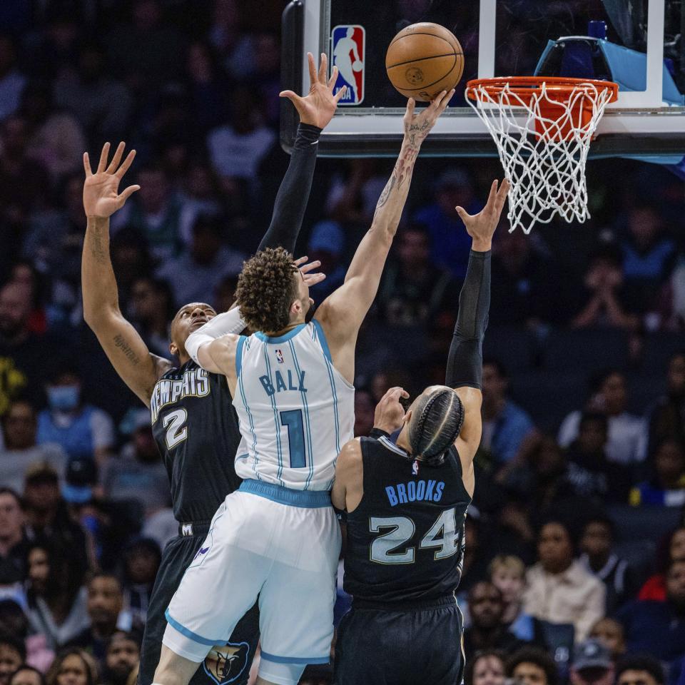 Charlotte Hornets guard LaMelo Ball (1) splits Memphis Grizzlies forward Xavier Tillman (2) and forward Dillon Brooks (24) during the first half of an NBA basketball game on Wednesday, Jan. 4, 2023, in Charlotte, N.C. (AP Photo/Scott Kinser)