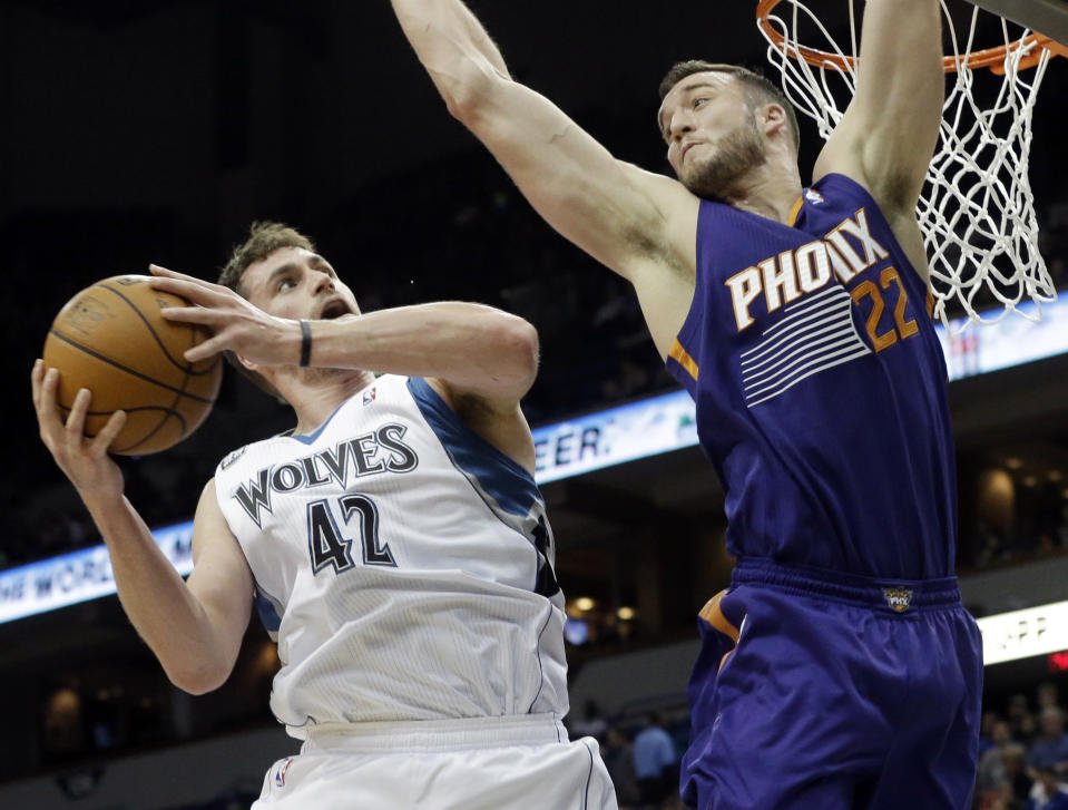 Minnesota Timberwolves' Kevin Love eyes a possible shot as Phoenix Suns' Miles Plumlee defends in the first quarter of an NBA basketball game on Wednesday, Jan. 8, 2014, in Minneapolis. (AP Photo/Jim Mone)