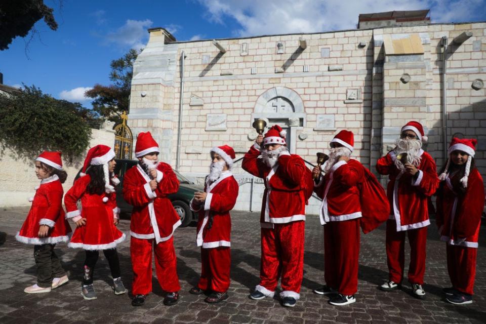 Palestinian children dressed as Santa Claus outside the Church of Saint Porphyrius in Gaza