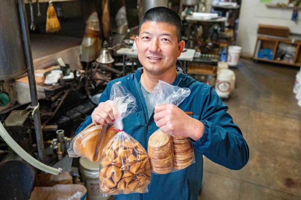 Yasheng Feng, owner of New World Co., holds freshly made fortune cookies in his downtown Sacramento factory in April.