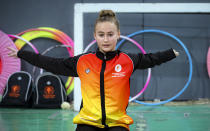 Sara Becarevic warms before performing a gymnastics routine in Visoko, Bosnia, Wednesday, Dec. 1, 2021. In Bosnia, a poor, Balkan country which habitually marginalizes people with disabilities, a soon-to-be-14-year-old girl, born without her lower left arm, pursues her dream of becoming an internationally recognized rhythmic gymnast. Sara Becarevic says she got enchanted with the demanding sport as a toddler, while watching the world championships on television. (AP Photo)